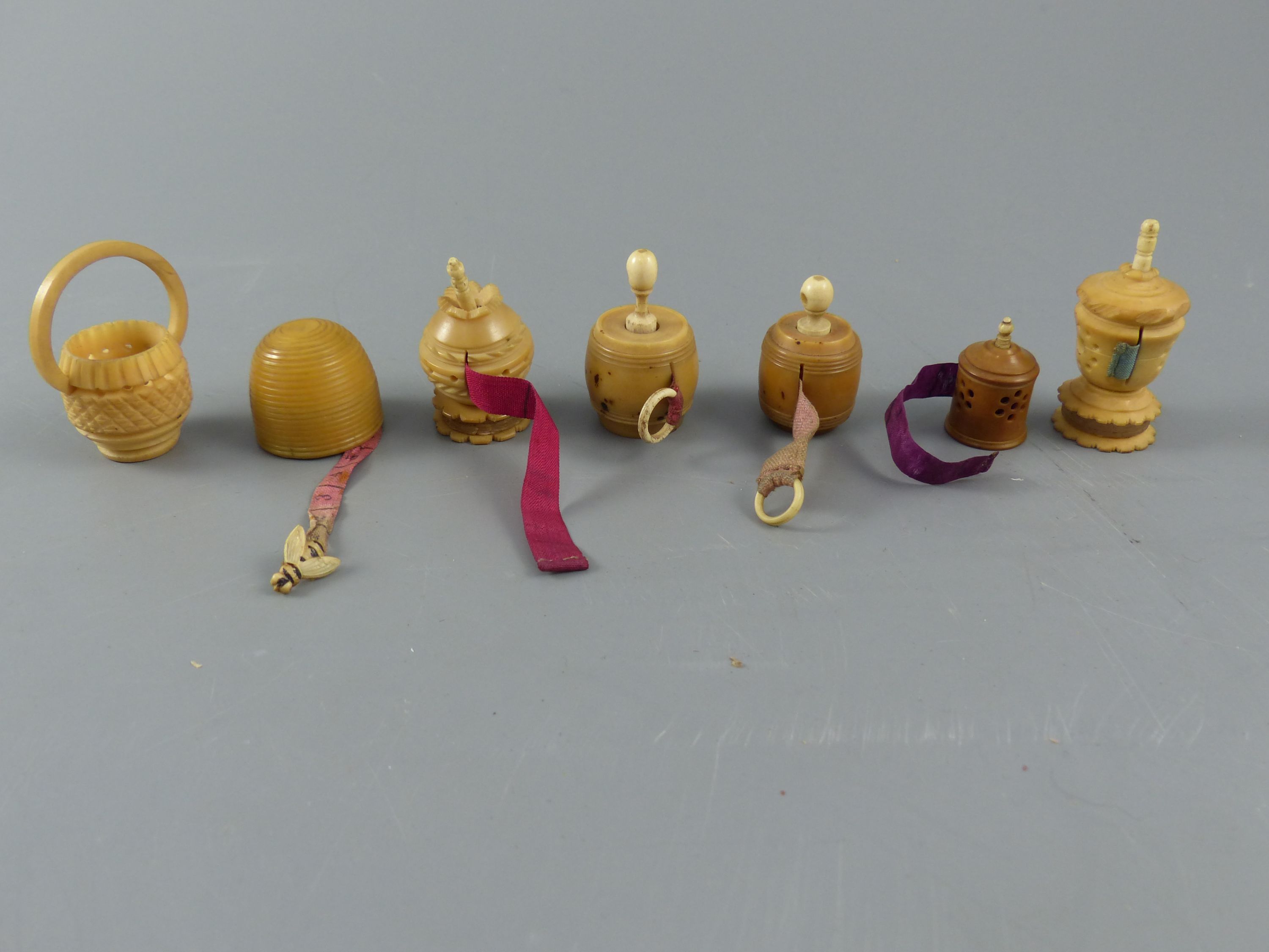 A collection of assorted 19th century carved and turned coquilla nut sewing accessories